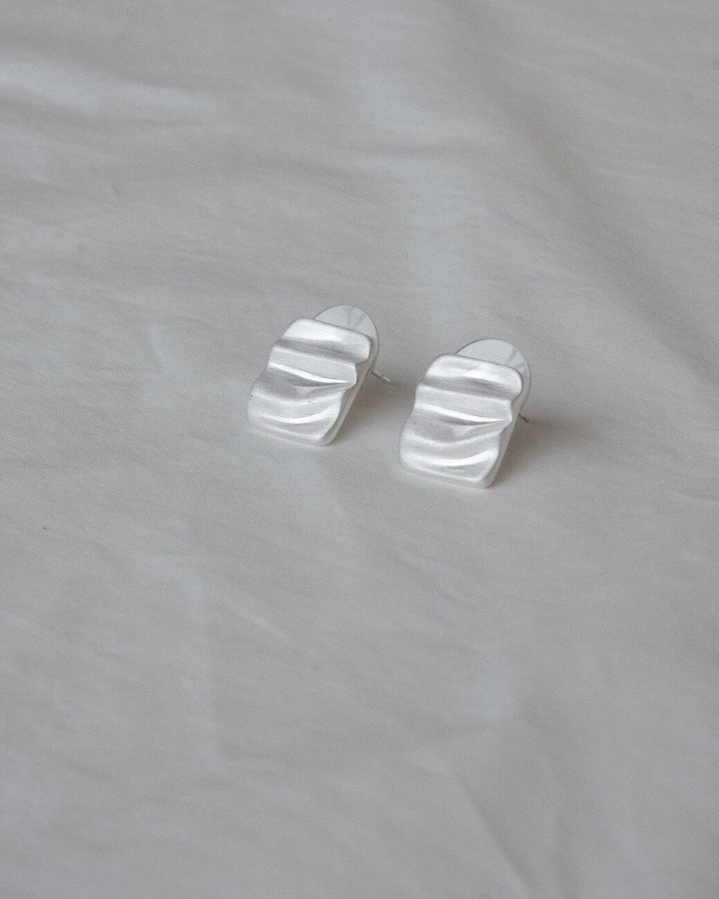 Pair of wavy rectangle copper stud earrings with silver posts and a textured, modern design - front view 2 - SWEEKU jewelry