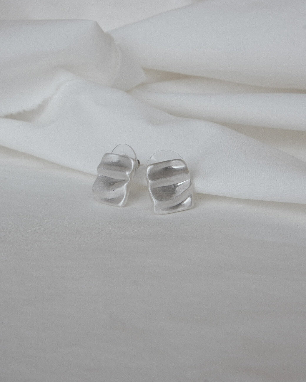 Pair of wavy rectangle copper stud earrings with silver posts and a textured, modern design - front view - SWEEKU jewelry