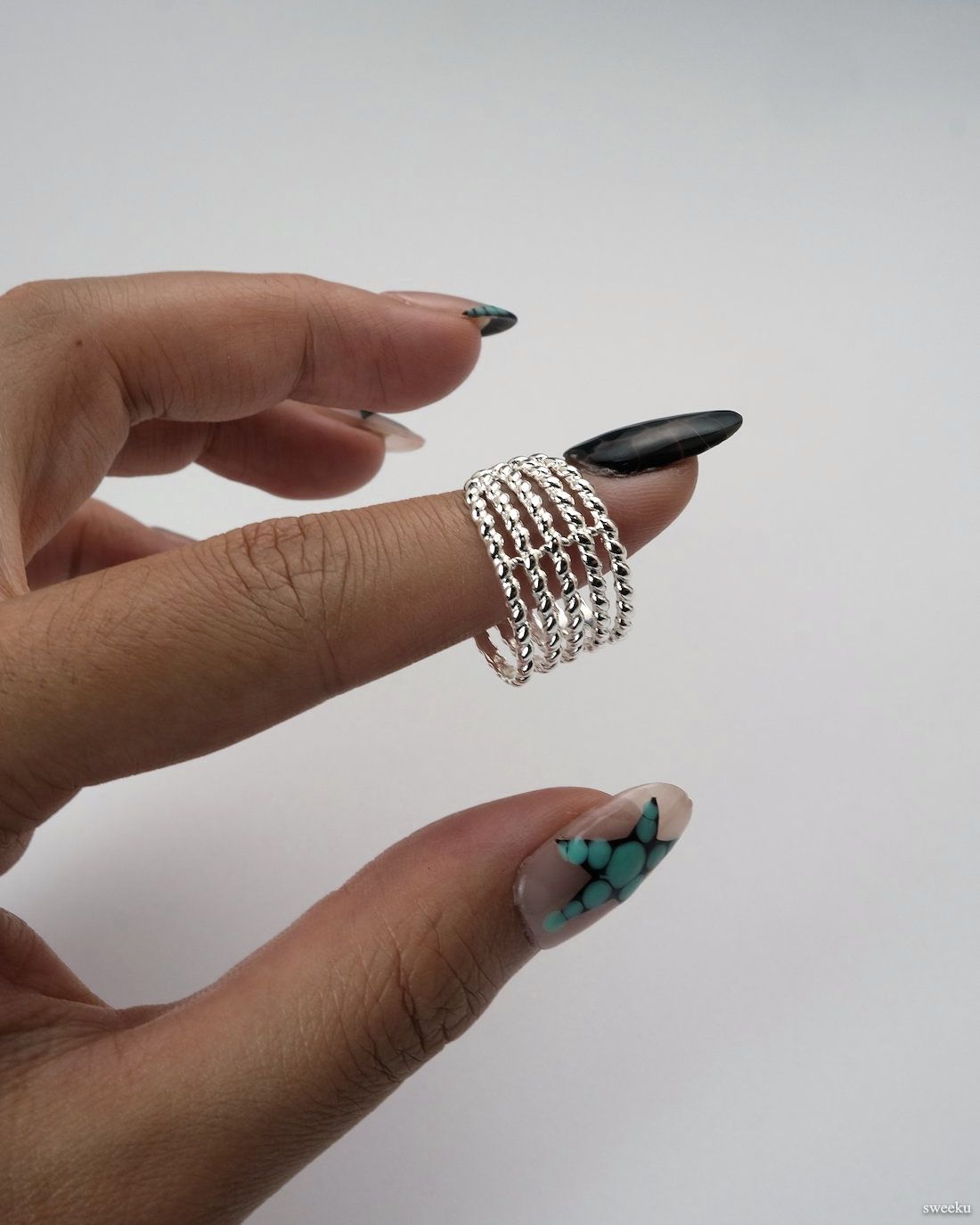 Adjustable silver multi-band twisted rope ring on white background