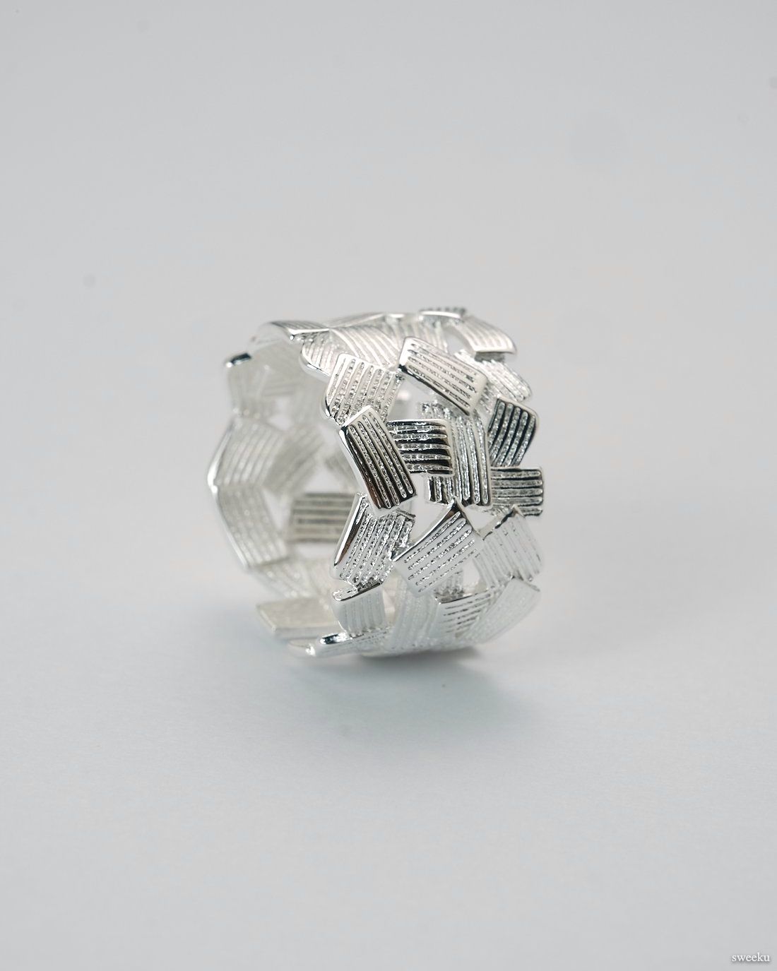 Adjustable silver-plated ring with interwoven lattice design on white background