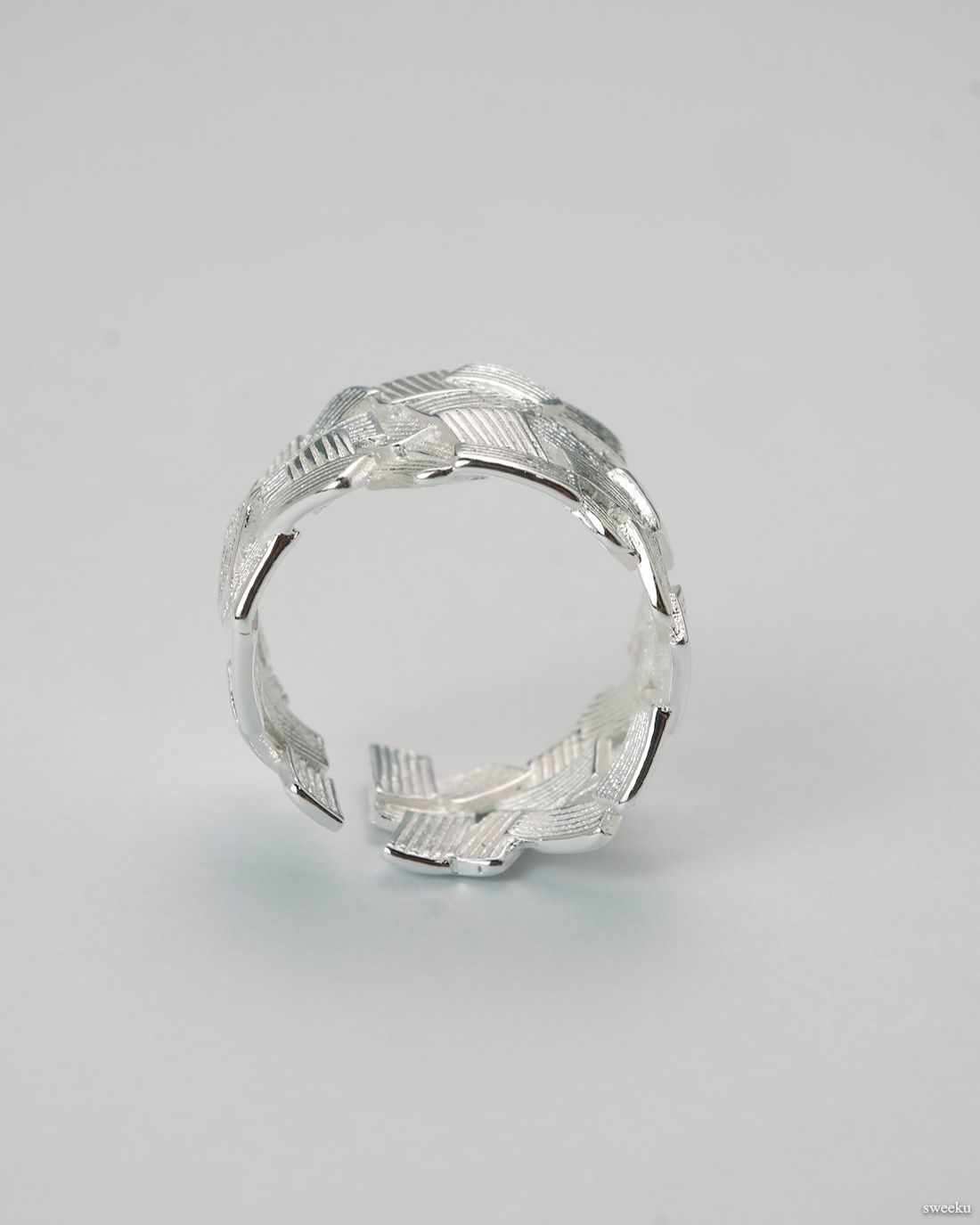 Weave Echo Ring worn on hand, bold silver woven band with polished texture