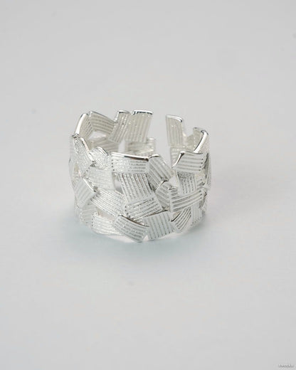 Adjustable silver-plated ring with interwoven lattice design on white background