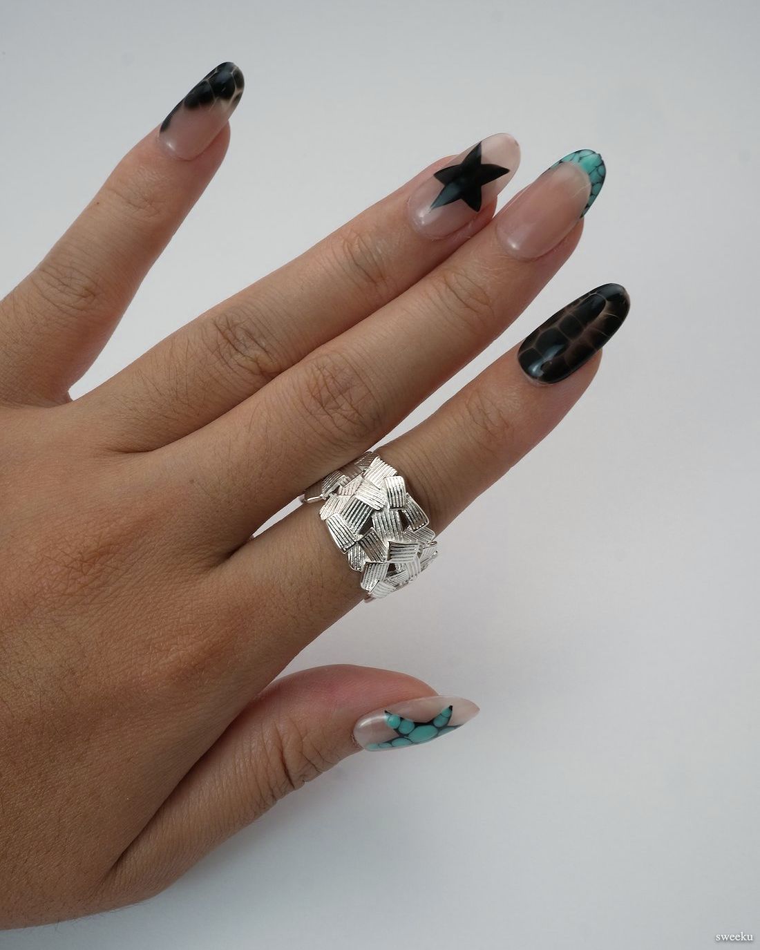 Weave Echo Ring worn on hand, bold silver woven band with polished texture